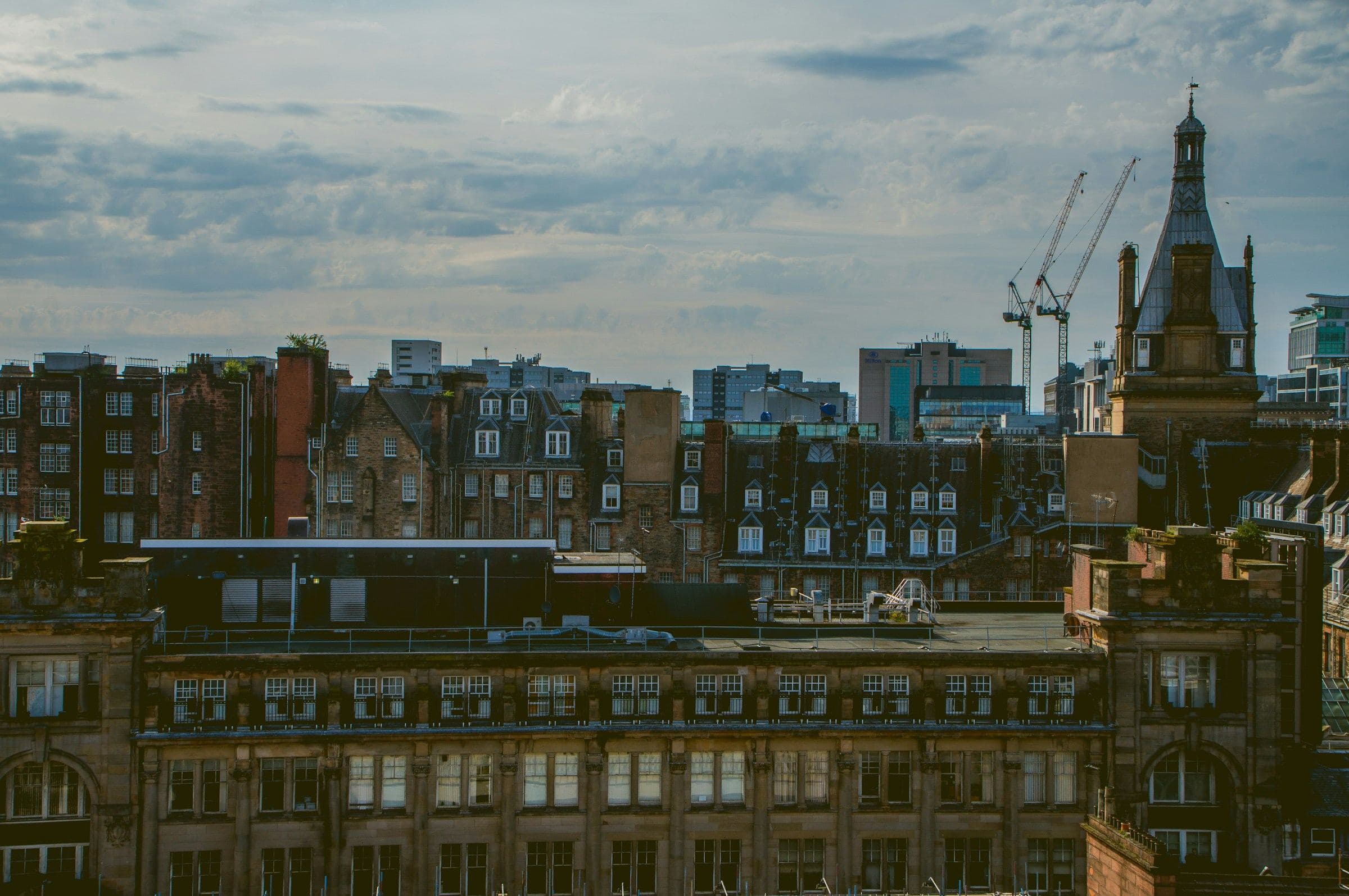 Rooftops, dormer windows and a spire across central Glasgow