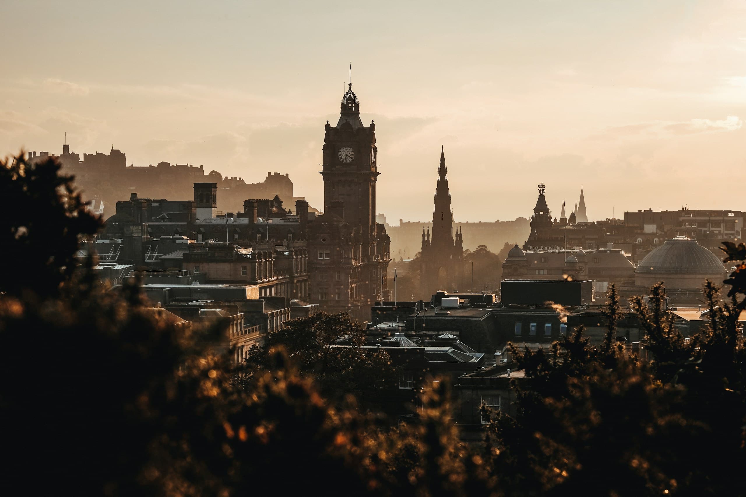 Edinburgh's skyline at dusk: the Balmoral clock tower, the Scott Monument and the castle in silhouette
