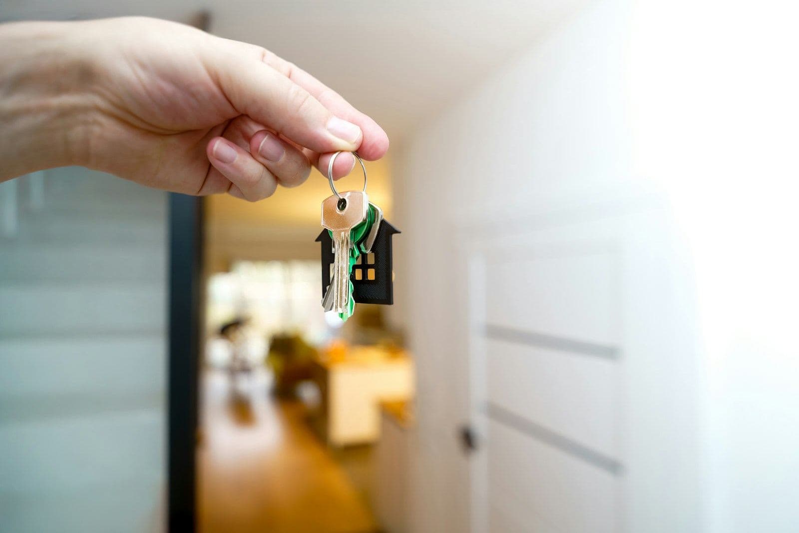 A set of house keys on a ring, held out inside a bright flat